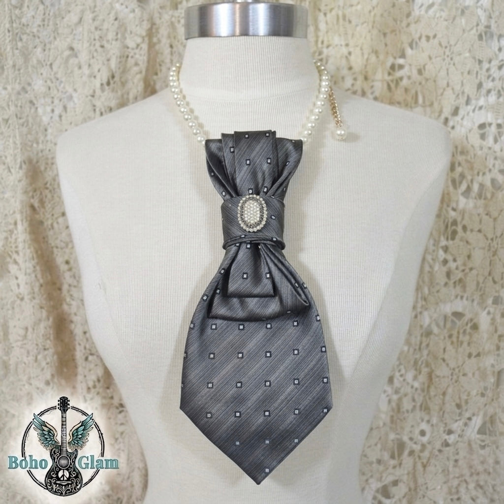 Gray bow tie with decorative center on a mannequin against a textured beige background, brand 'Boho Glam' visible.