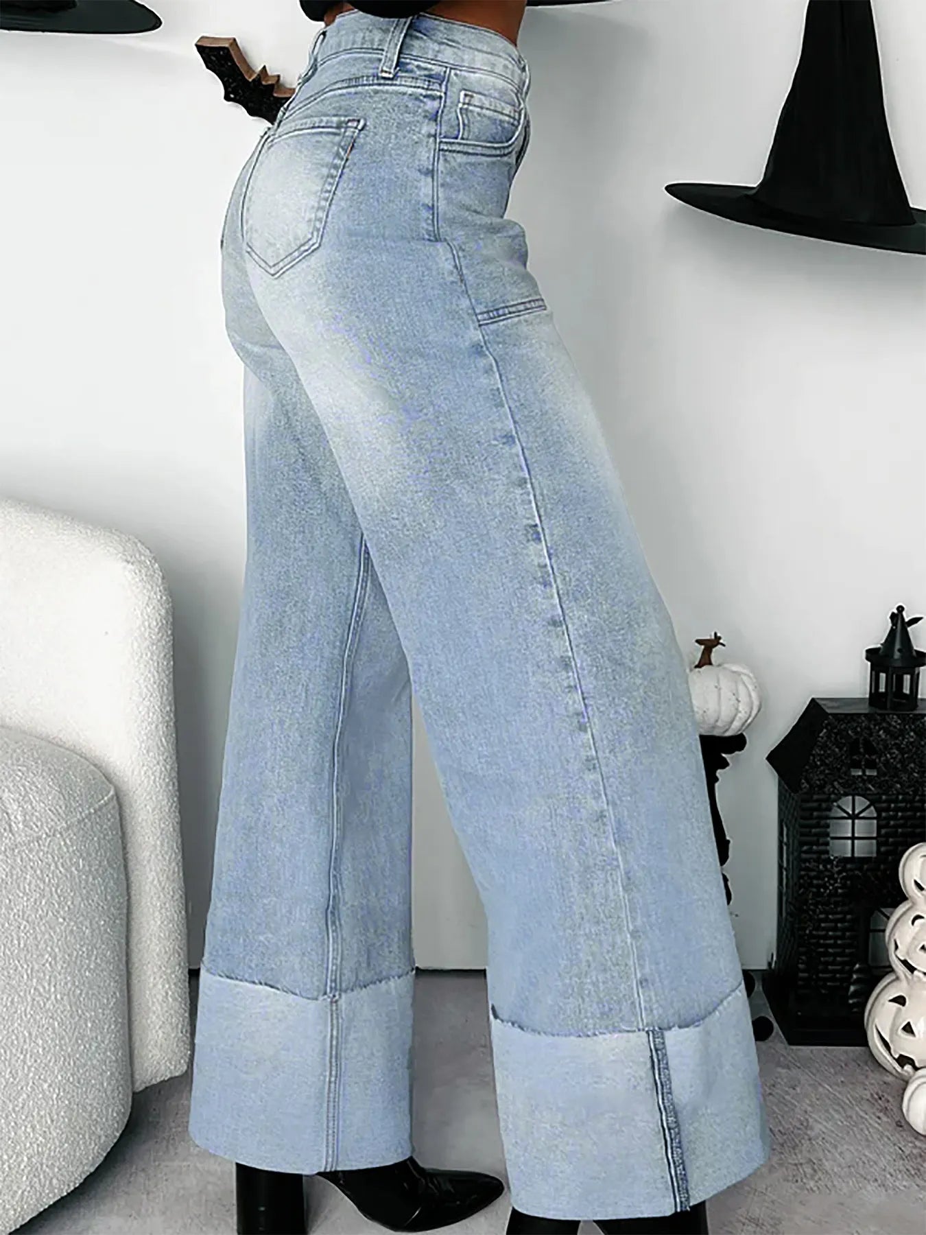 Light blue wide-leg jeans, side-view worn by a person indoors.