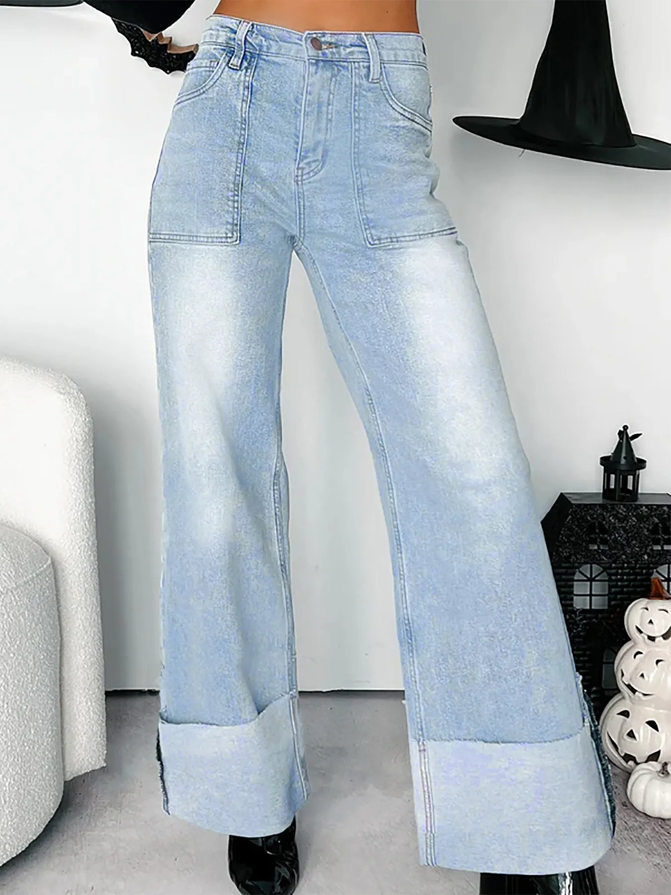 Light blue wide-leg jeans worn by a person in a minimal indoor setting.
