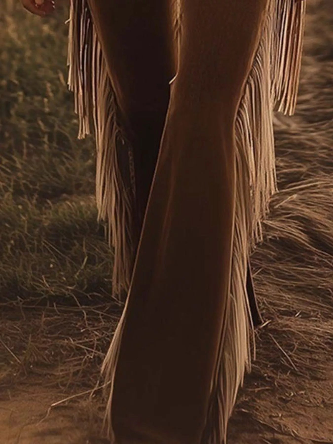 Close-up of a person wearing fringed boots in a natural setting