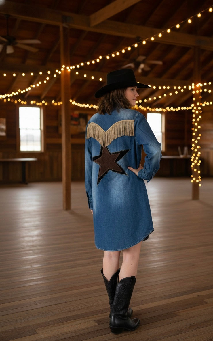 Person wearing a blue denim jacket with a star design in a wooden building with string lights.