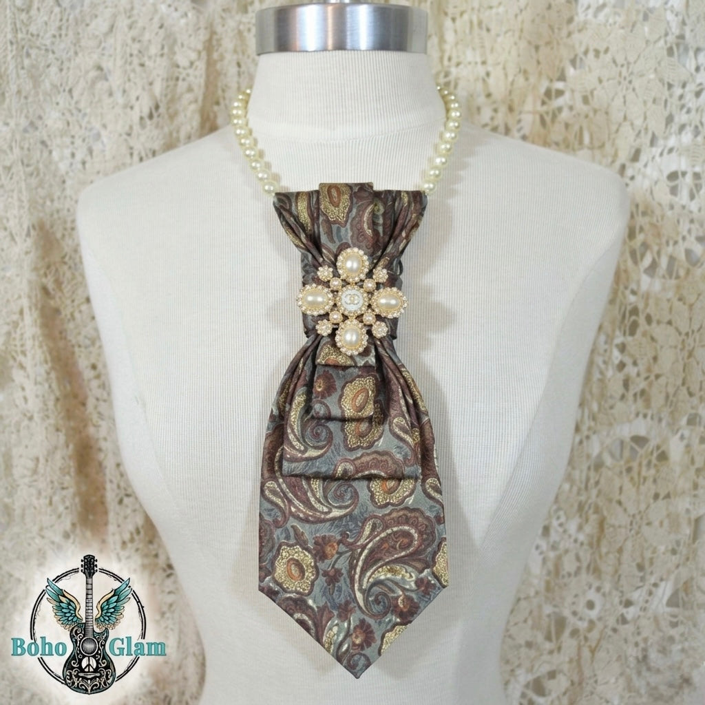 Patterned tie with decorative elements on a mannequin against a textured beige background, featuring the brand 'Boho Glam'.