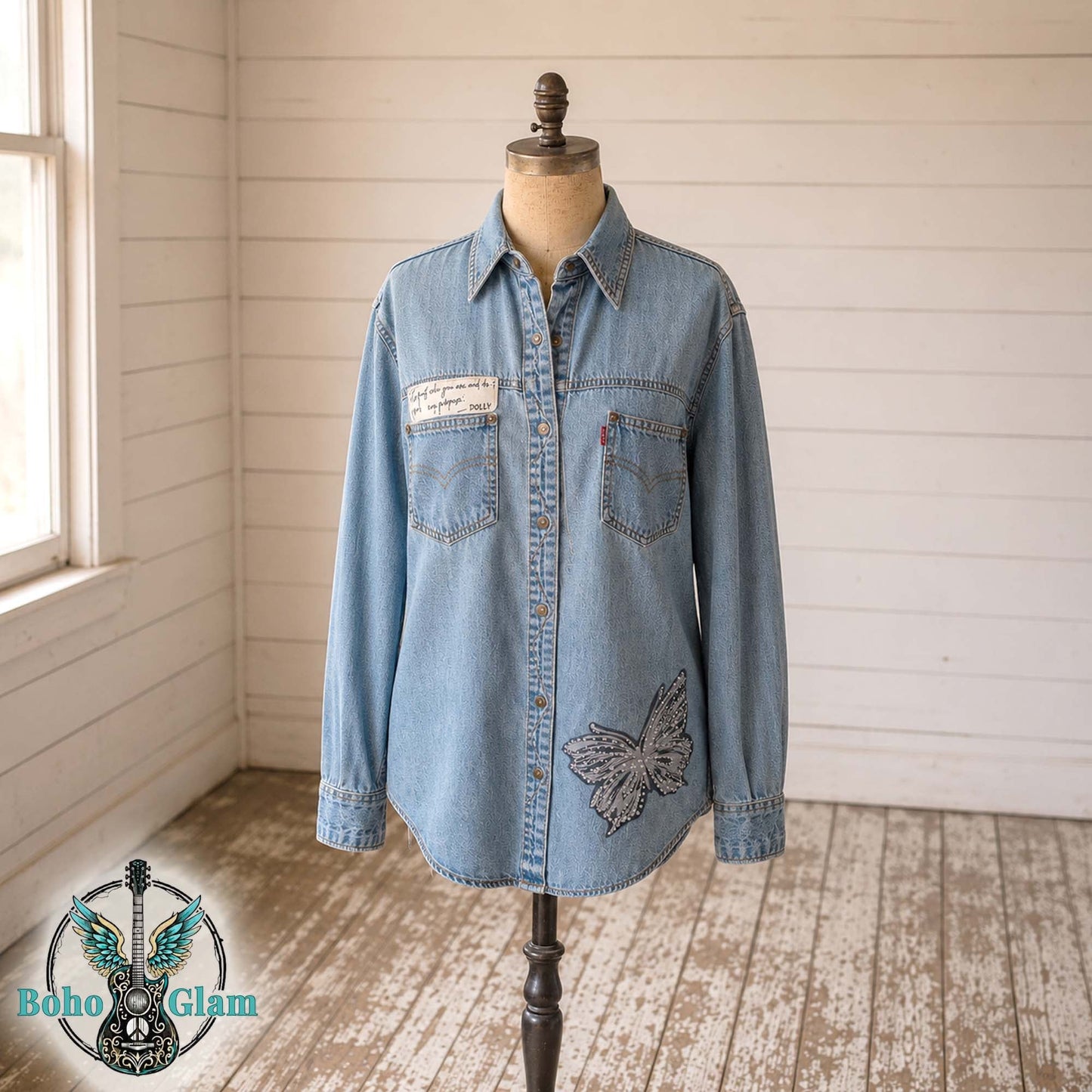 Light blue denim shirt on a mannequin against a wooden wall with 'Boho Glam' logo.