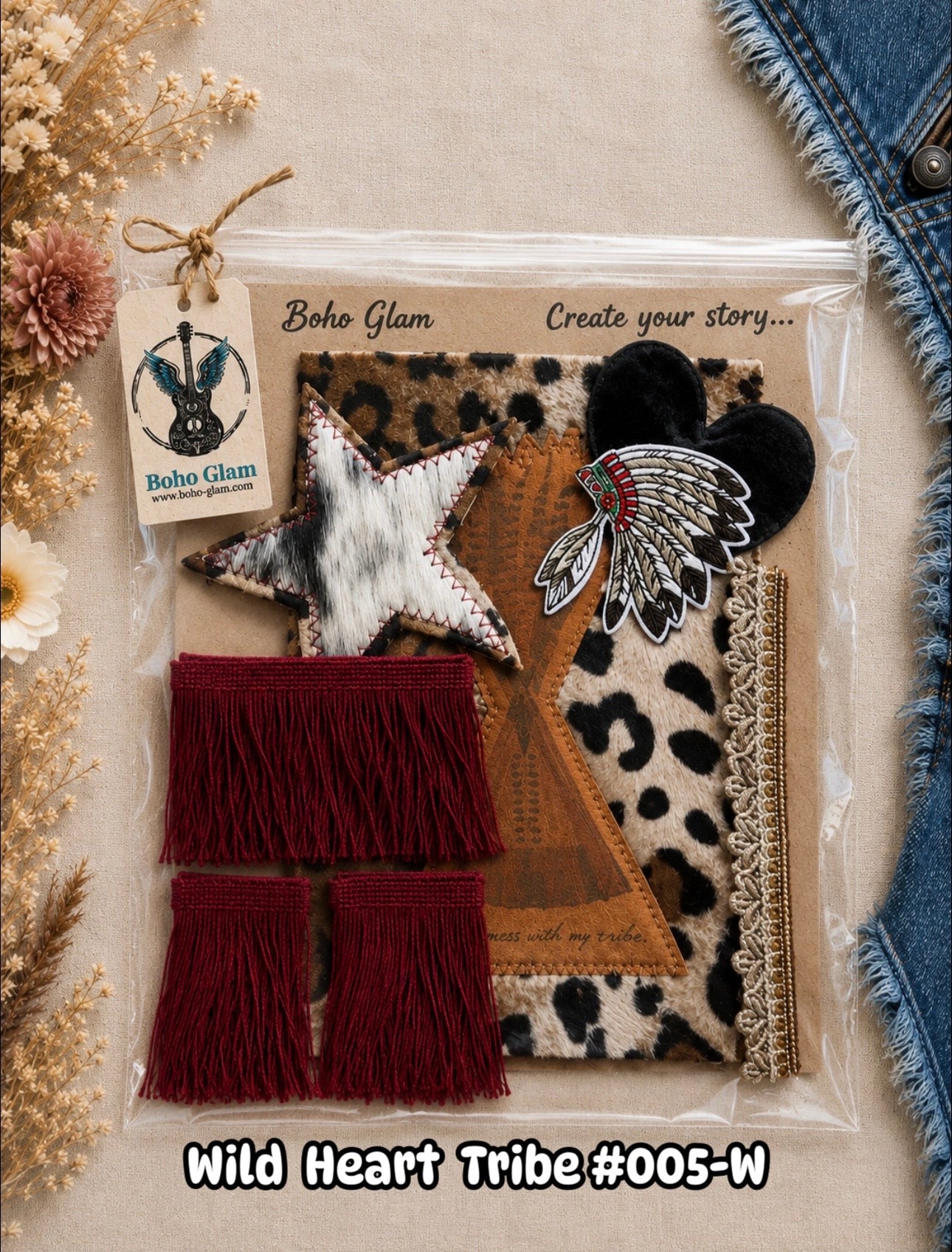Boho Glam 'Wild Heart Tribe' craft kit (#005-W) containing various tribal-inspired fabric and leather accessories, including a star patch, feather patch, leopard print fabric, and red fringe tassels, displayed in a clear plastic bag on a neutral background with dried flowers and denim.