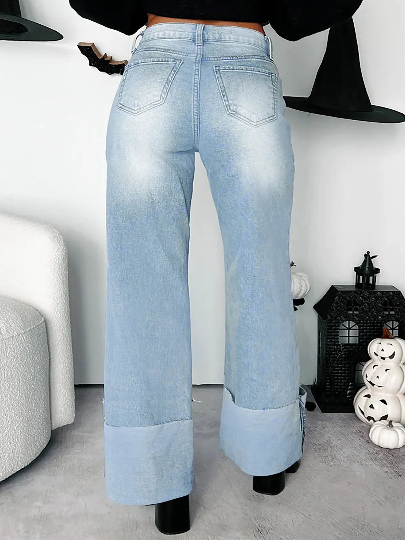 Backside, Light blue jeans worn by a person in a room with Halloween decorations.