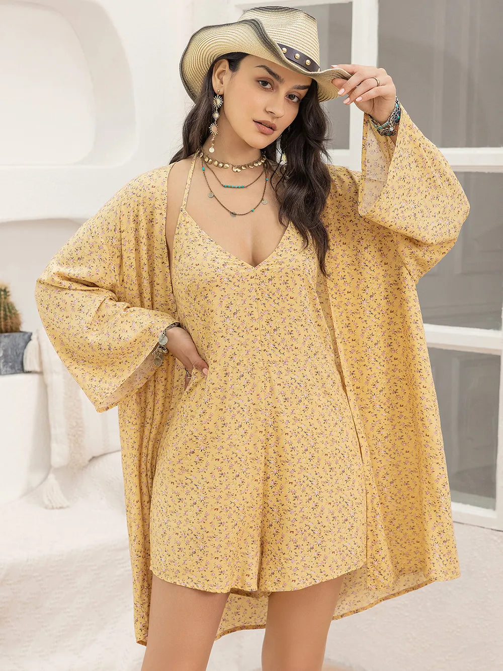 Woman wearing a yellow floral dress and cowboy hat indoors