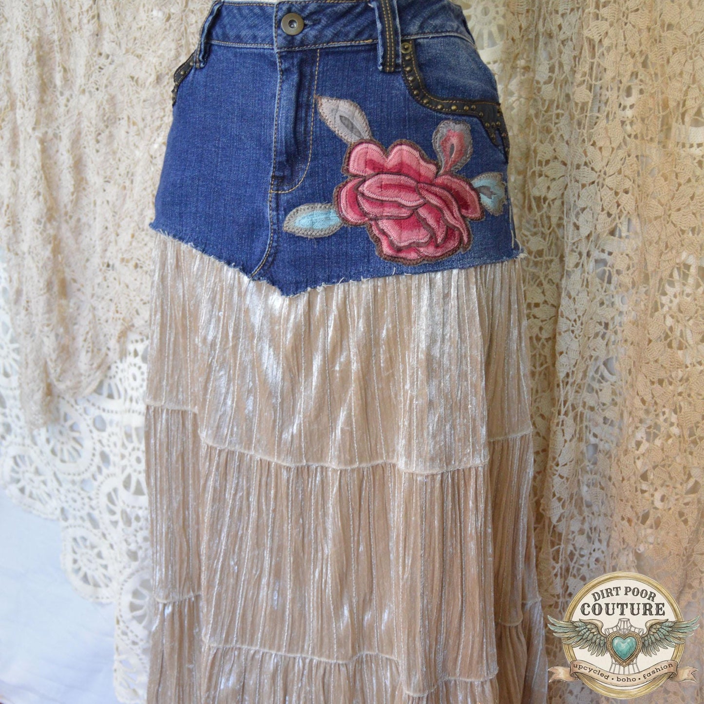 A detailed shot of the intricate red and pink peony embroidered applique below the studded denim pocket