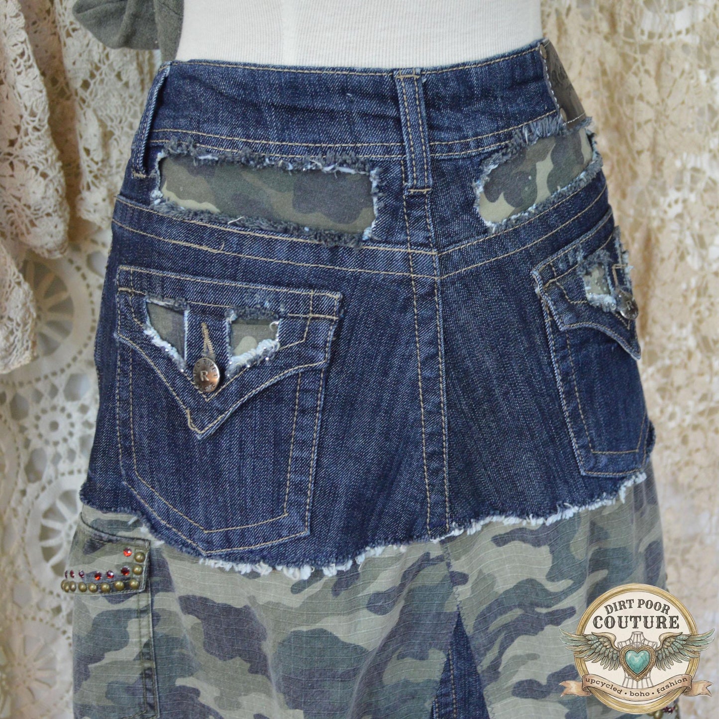 Close-up of the immaculate metal studding and sparkling rhinestone embellishments on the dark denim and camouflage background.