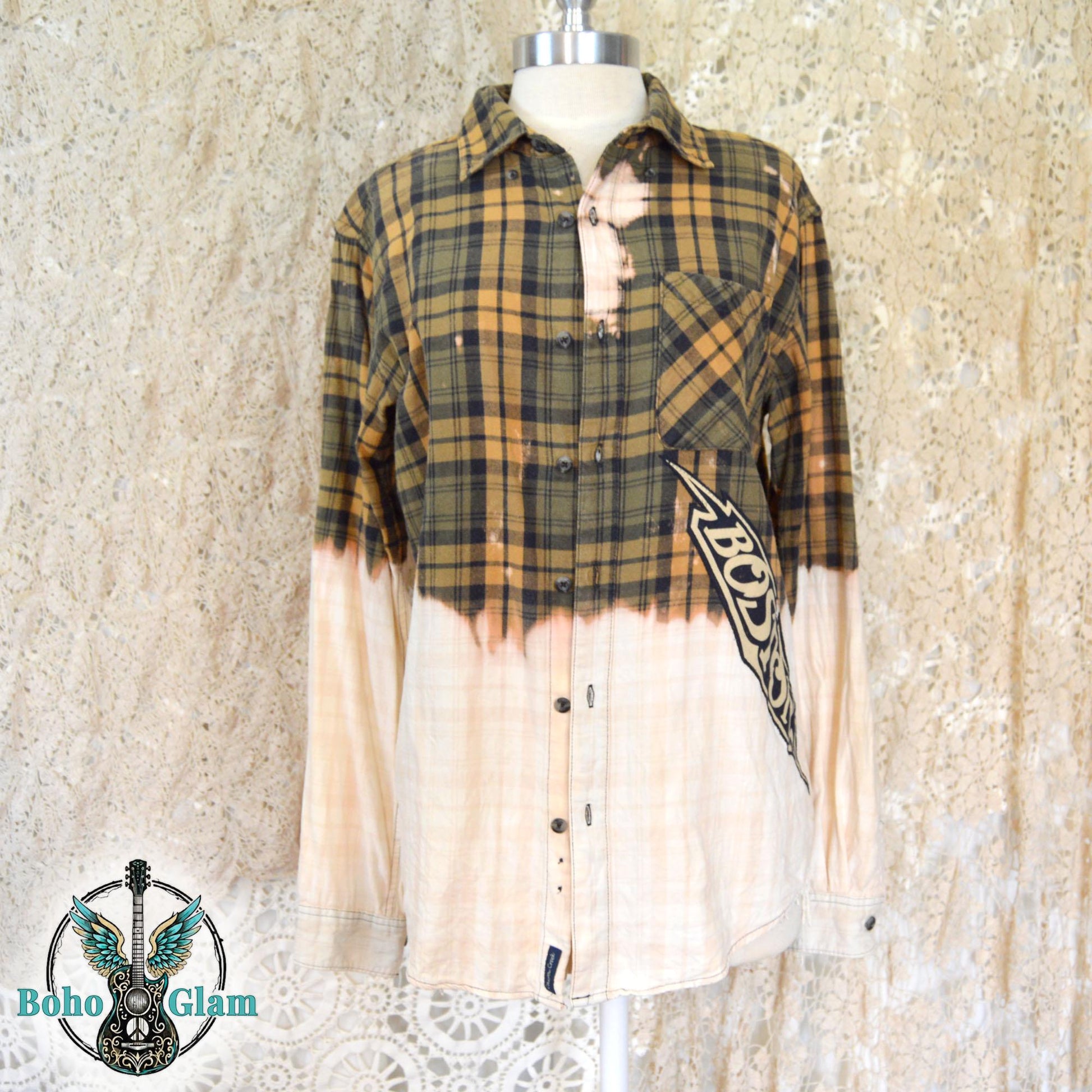 The front of a bleached yellow plaid flannel featuring a diagonal Boston logo applique and distressed dip-bleach effect on the bottom and sleeves.