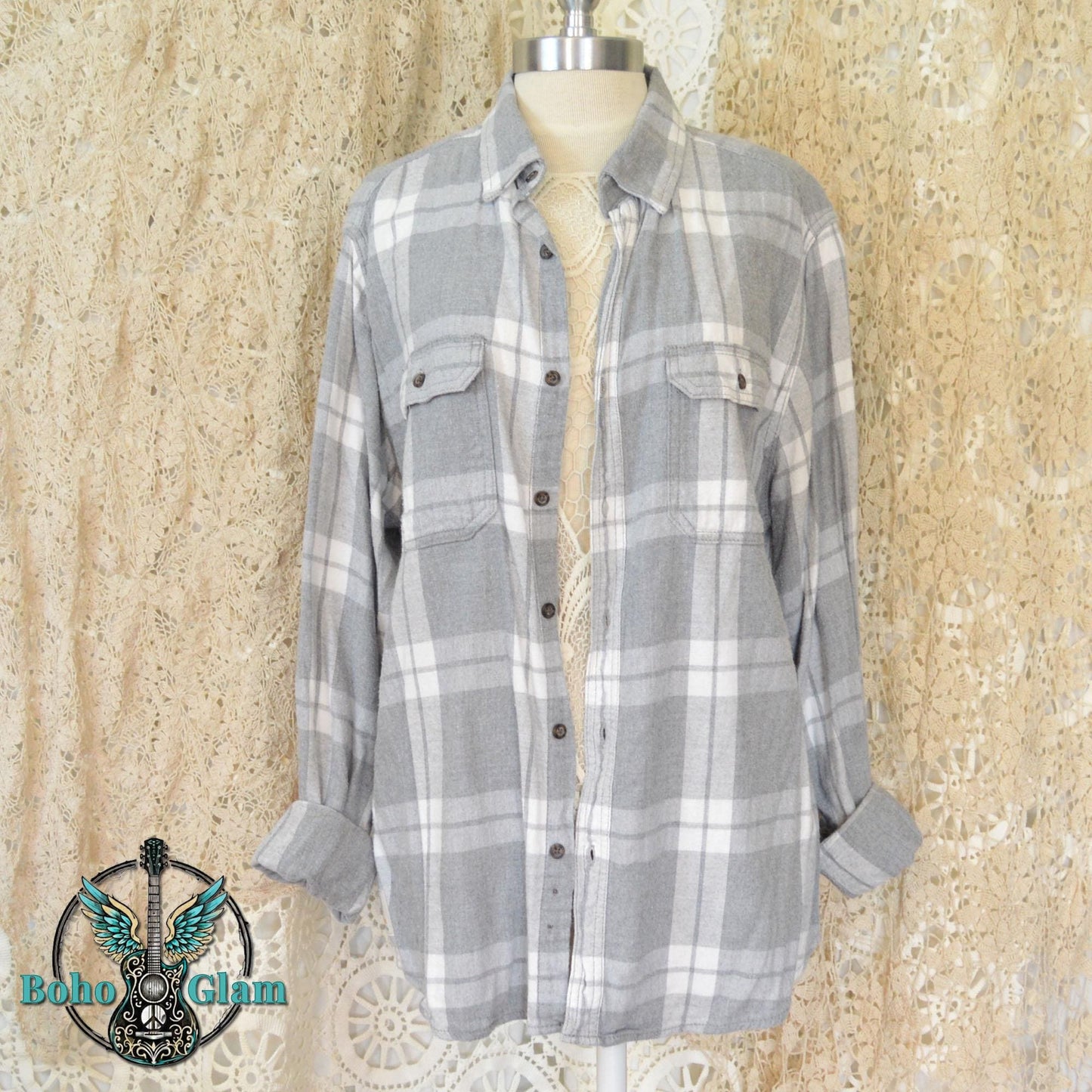 Front View: The front of a classic grey and white plaid button down flannel shirt with two chest pockets displayed on a mannequin.
