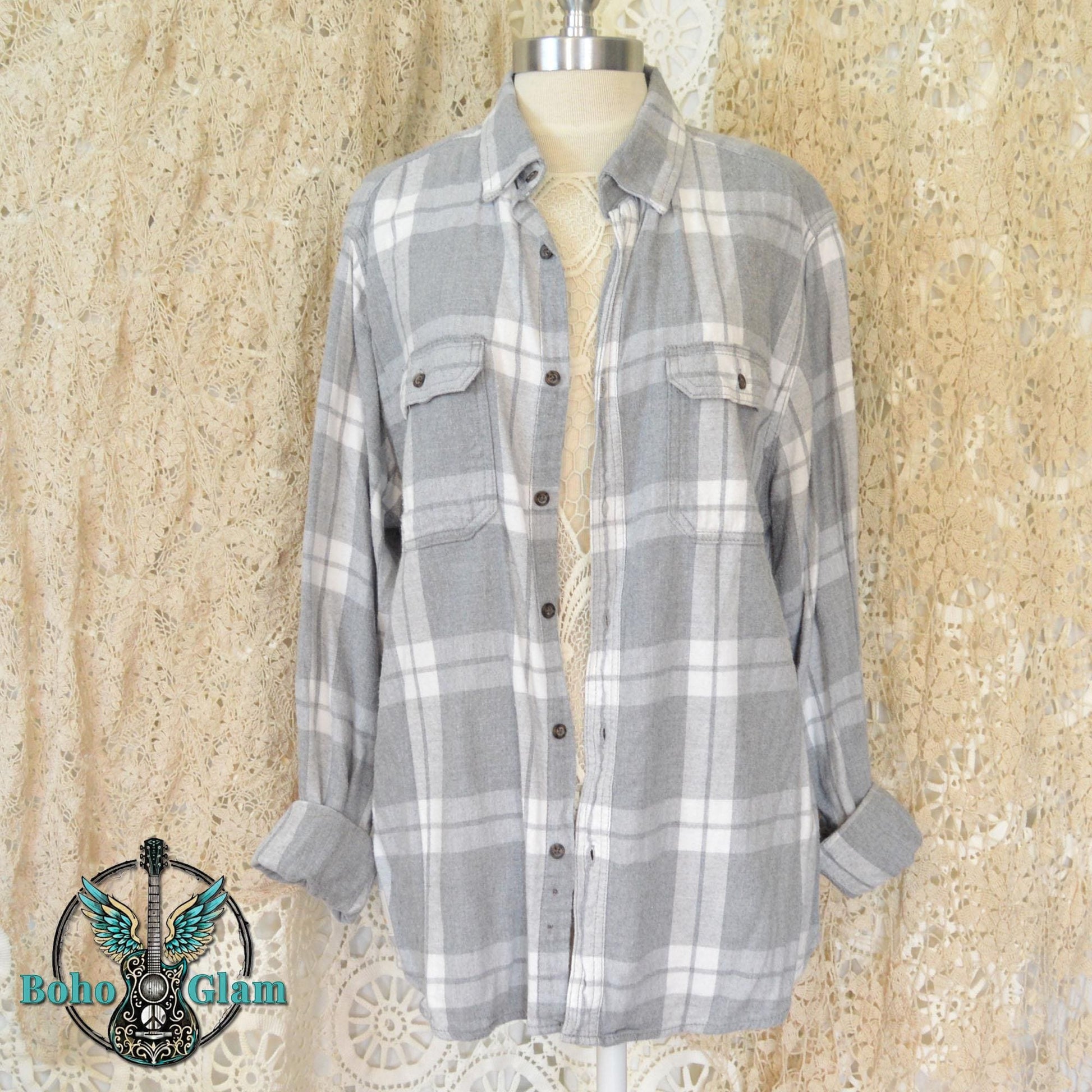 Front View: The front of a classic grey and white plaid button down flannel shirt with two chest pockets displayed on a mannequin.