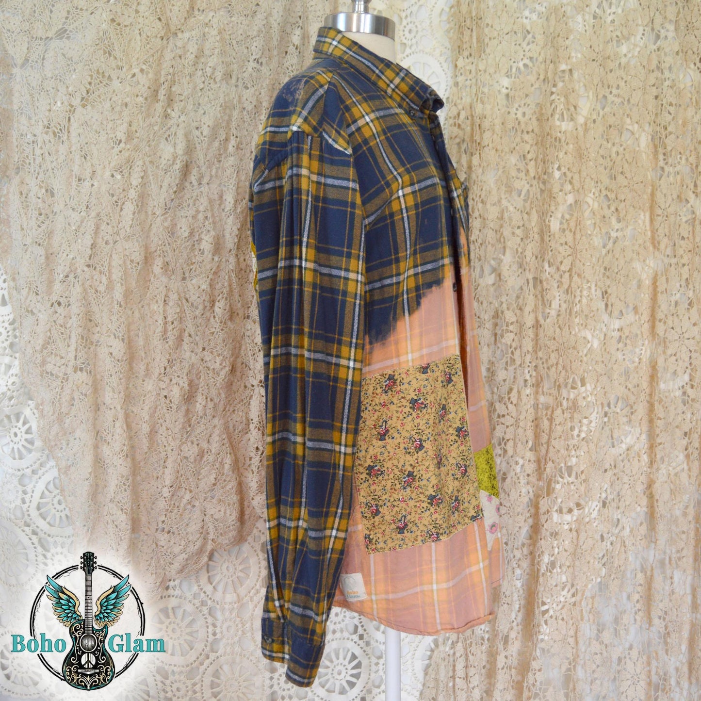 Front View: The front of a bleached plaid flannel shirt on a mannequin showing colorful floral patchwork and heart appliques on the chest pocket.