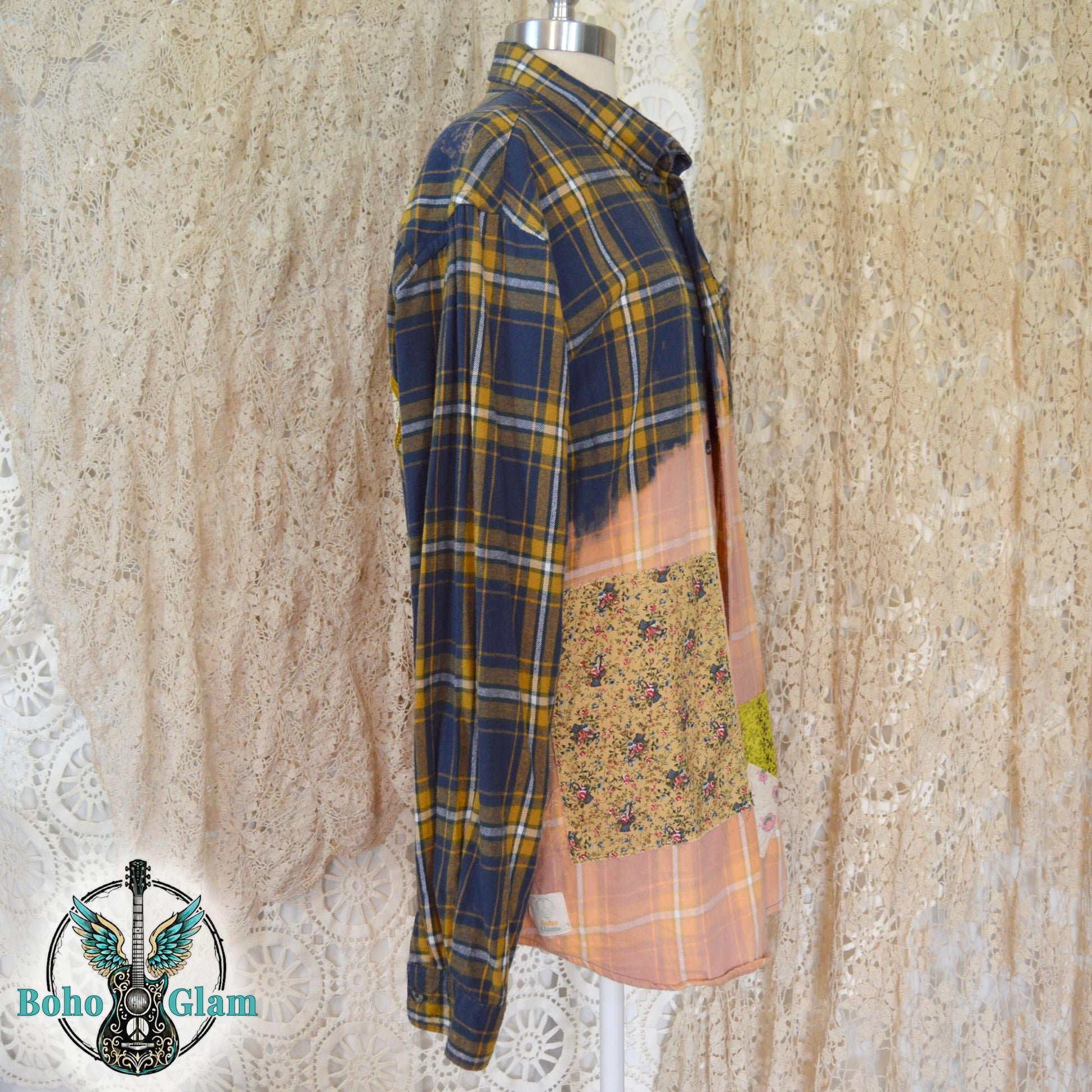 Front View: The front of a bleached plaid flannel shirt on a mannequin showing colorful floral patchwork and heart appliques on the chest pocket.