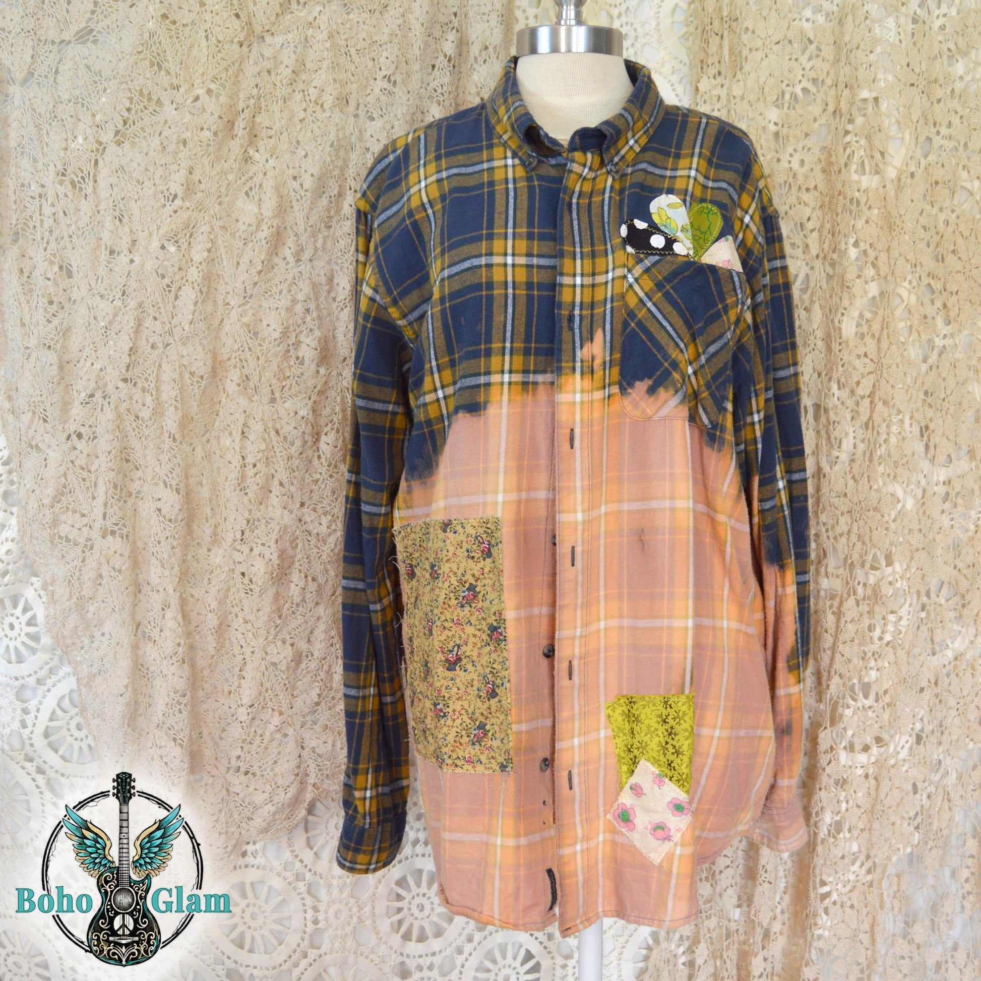 Front View: The front of a bleached plaid flannel shirt on a mannequin showing colorful floral patchwork and heart appliques on the chest pocket.