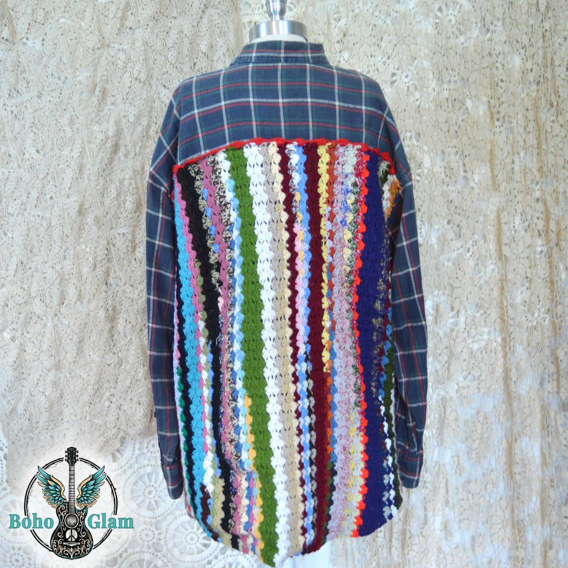 Back View on Mannequin: The upcycled plaid flannel shown on a mannequin, highlighting the full length of the multi-colored crochet back panel and its red scalloped top border.