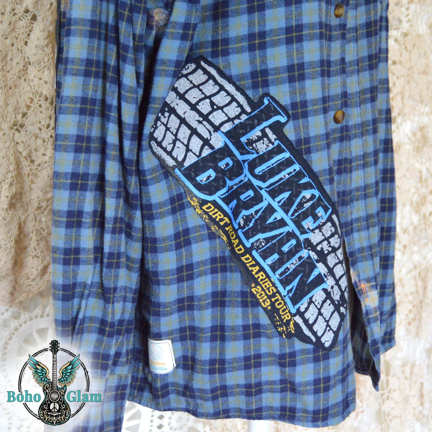 Front Close-up: A detailed shot of the front applique showing the Luke Bryan Dirt Road Diaries Tour 2013 logo with a tire track design on the blue plaid fabric.