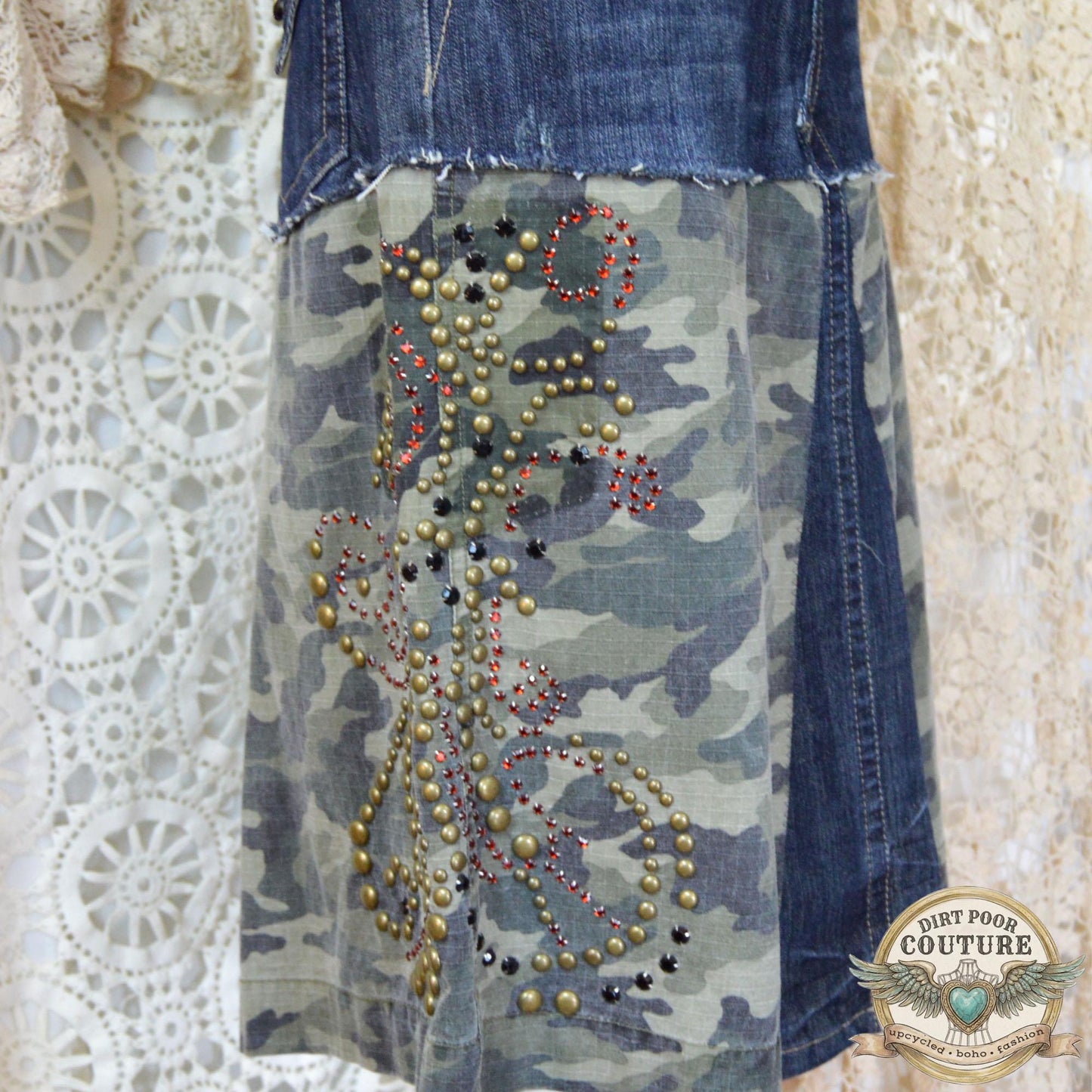 Close-up of the immaculate metal studding and sparkling rhinestone embellishments on the dark denim and camouflage background.