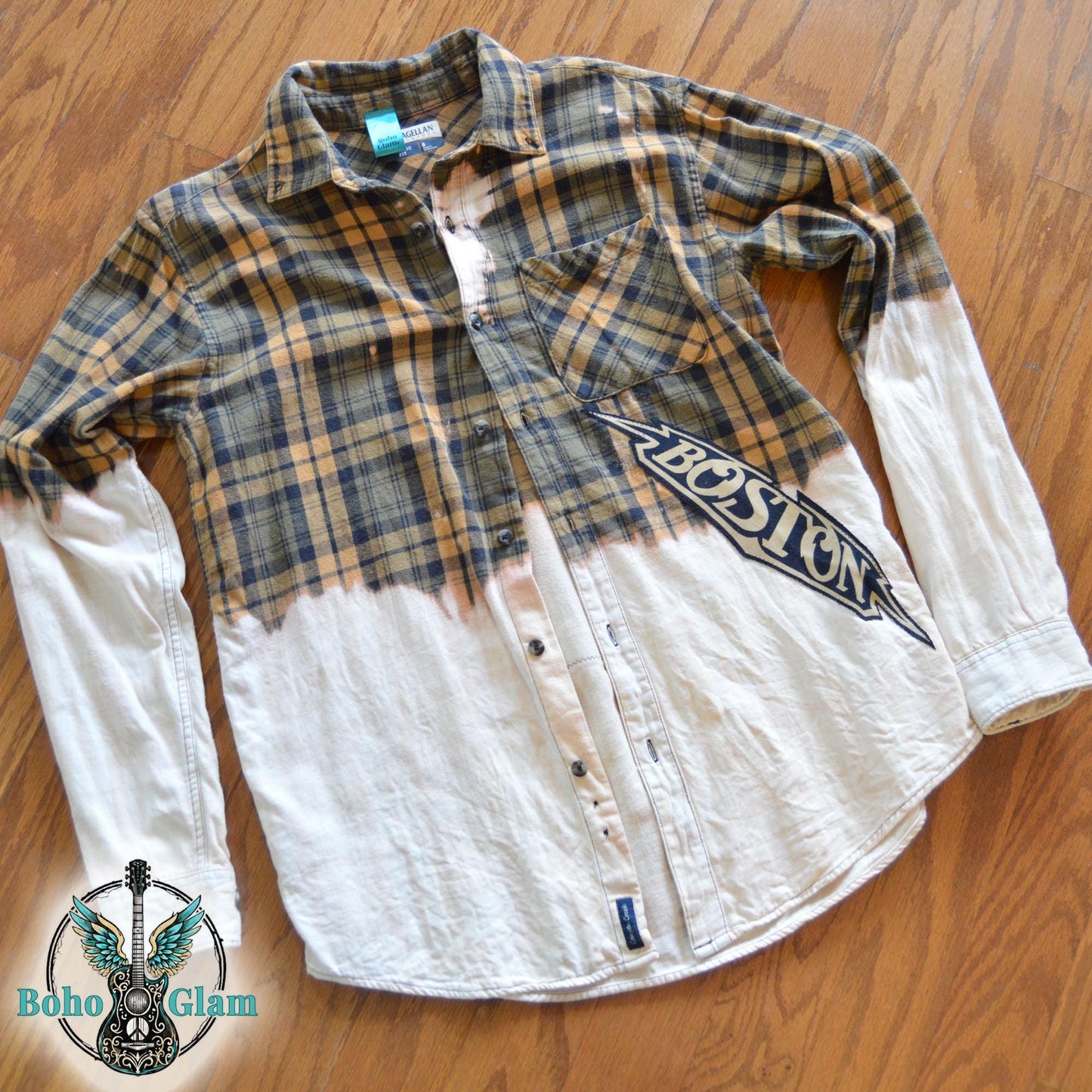 The front of a bleached yellow plaid flannel featuring a diagonal Boston logo applique and distressed dip-bleach effect on the bottom and sleeves.