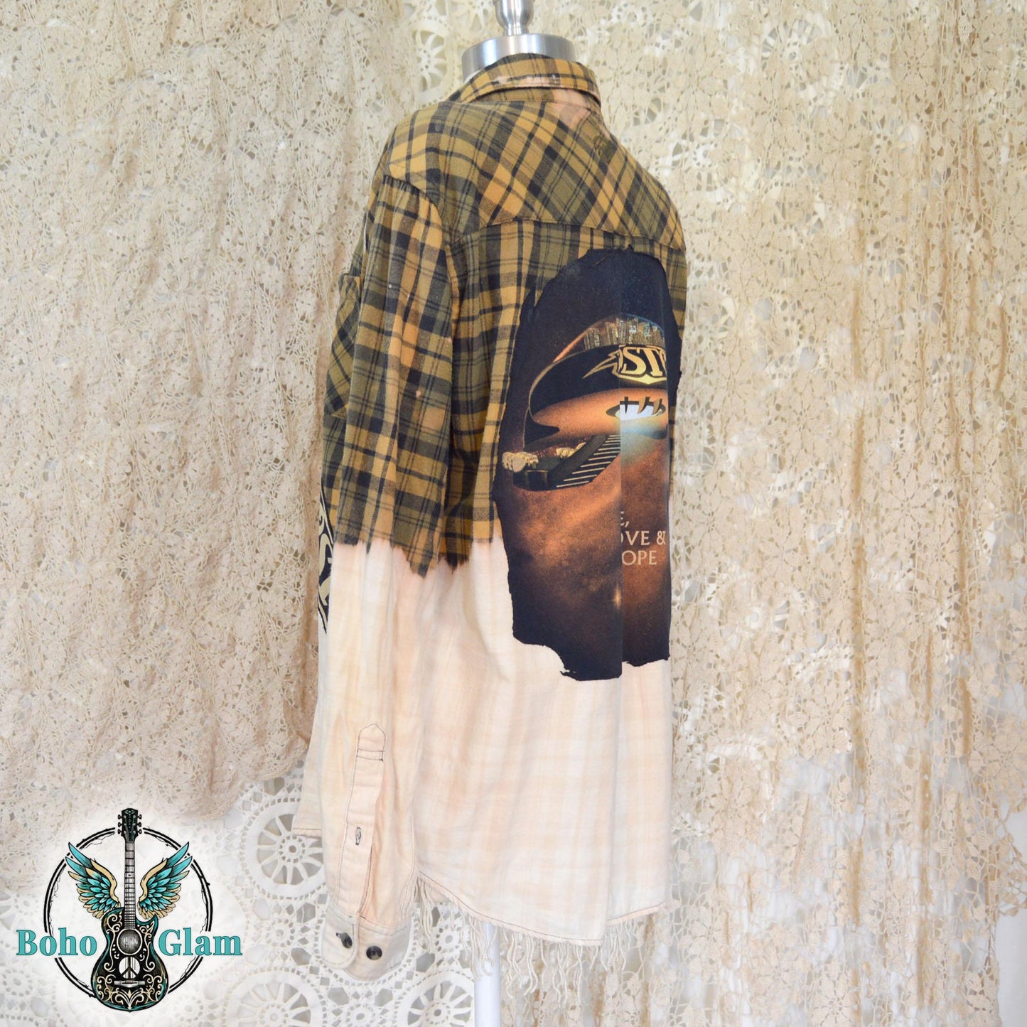 Back View: A yellow and black plaid flannel shirt with a bleached white bottom half and a large circular Boston band graphic appliqued on the back