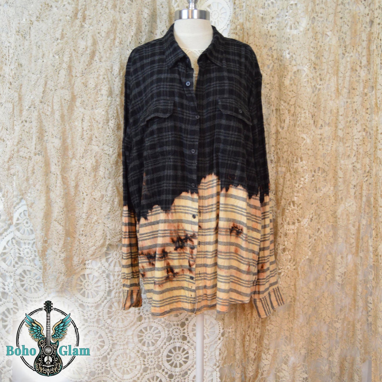 The front of a distressed black plaid flannel with a dip-bleach effect and button-down pockets on a mannequin