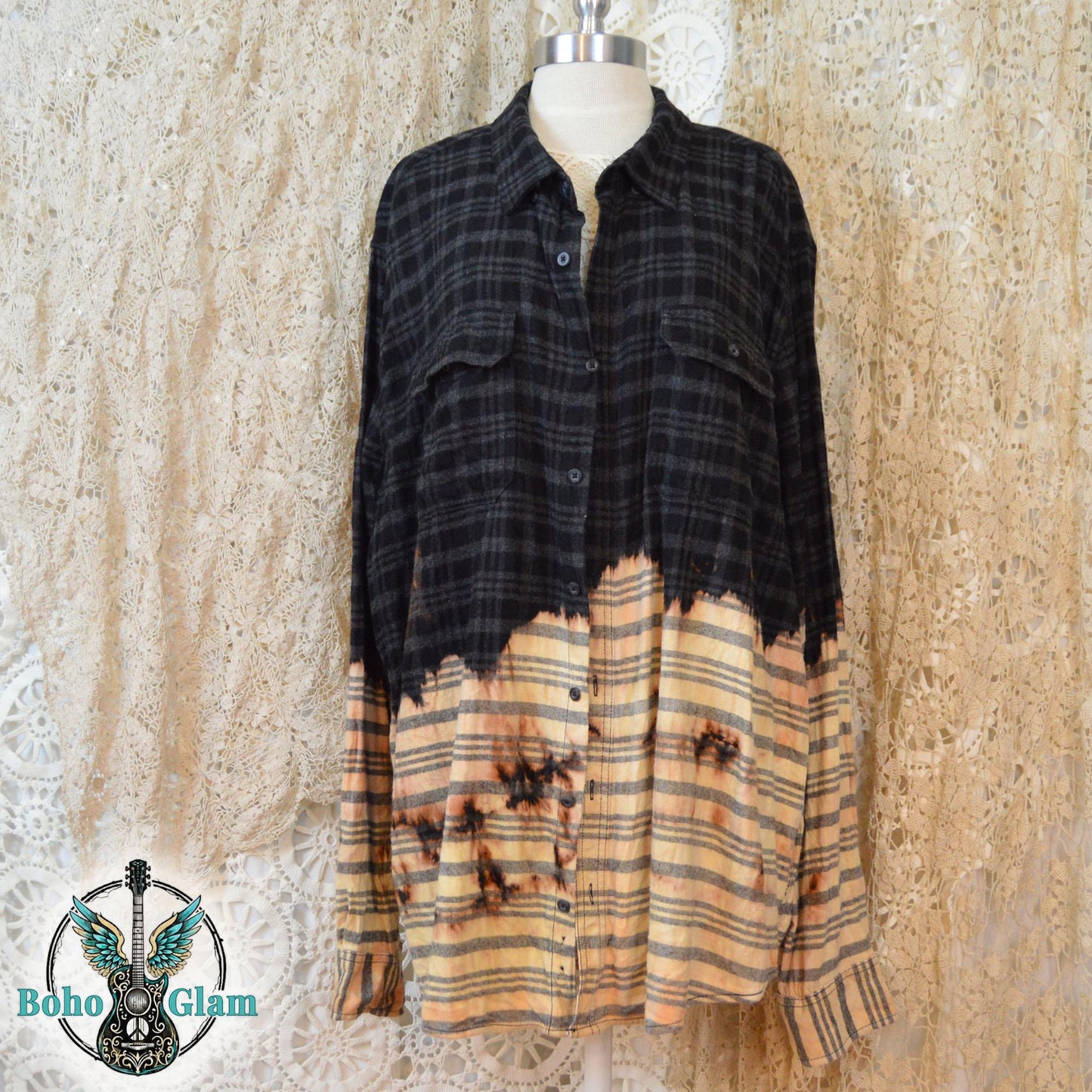 The front of a distressed black plaid flannel with a dip-bleach effect and button-down pockets on a mannequin