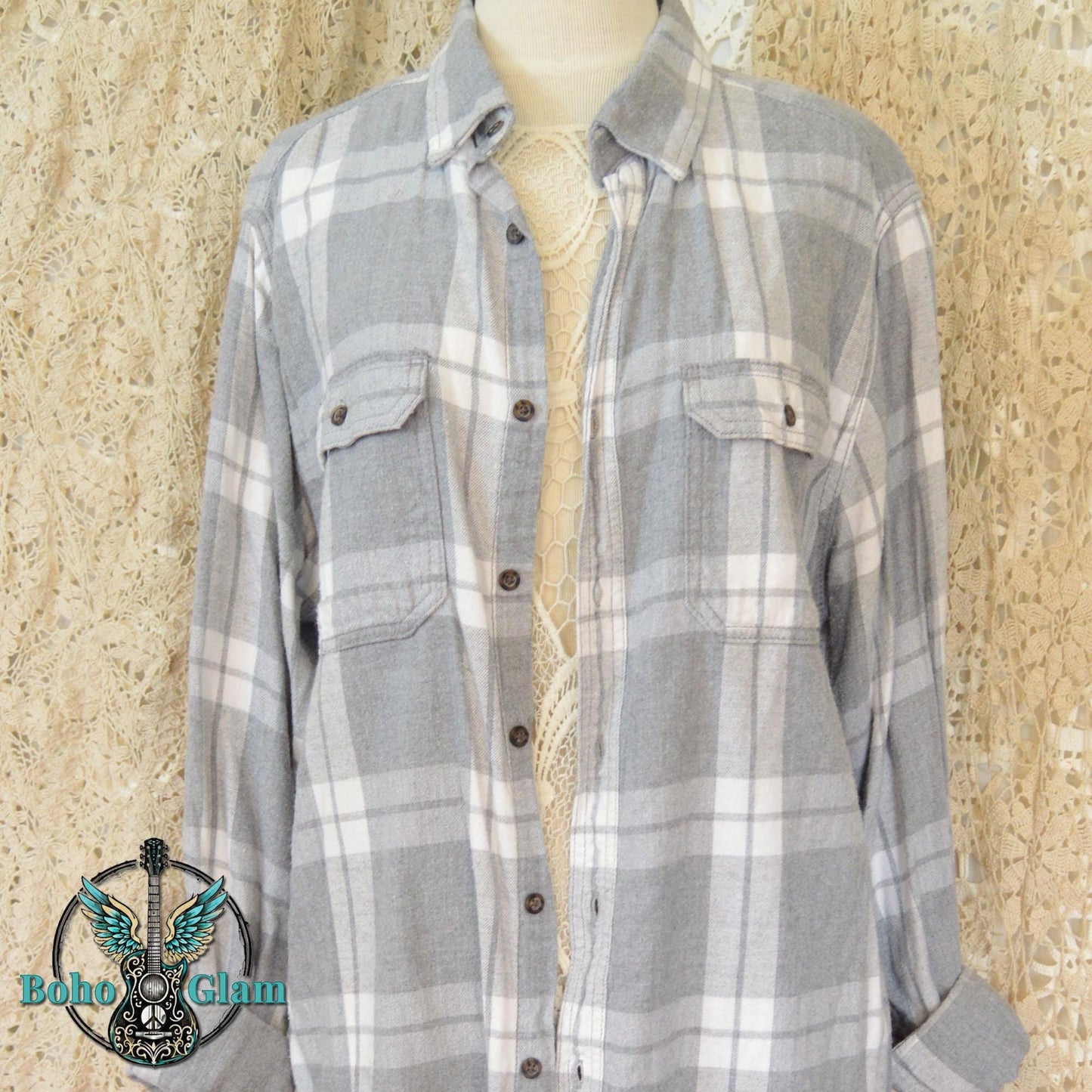 Front View: The front of a classic grey and white plaid button down flannel shirt with two chest pockets displayed on a mannequin.