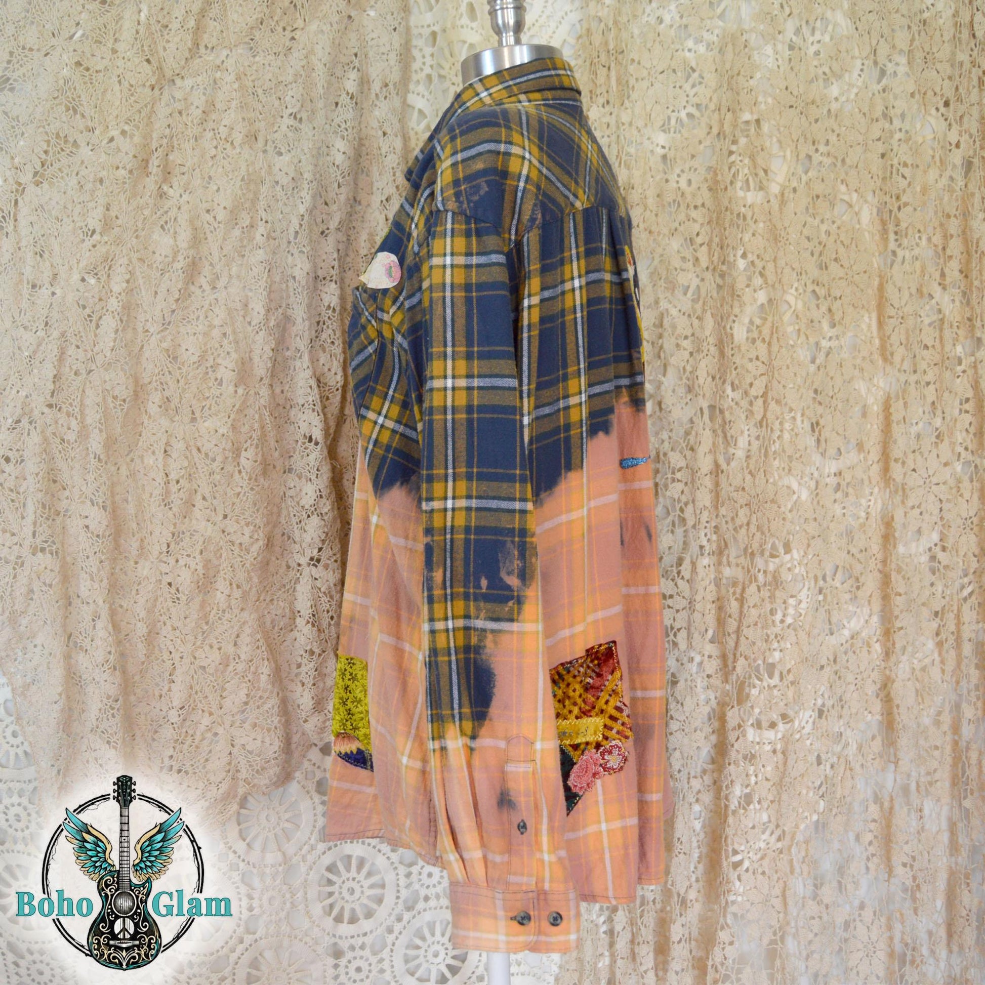 Front View: The front of a bleached plaid flannel shirt on a mannequin showing colorful floral patchwork and heart appliques on the chest pocket.