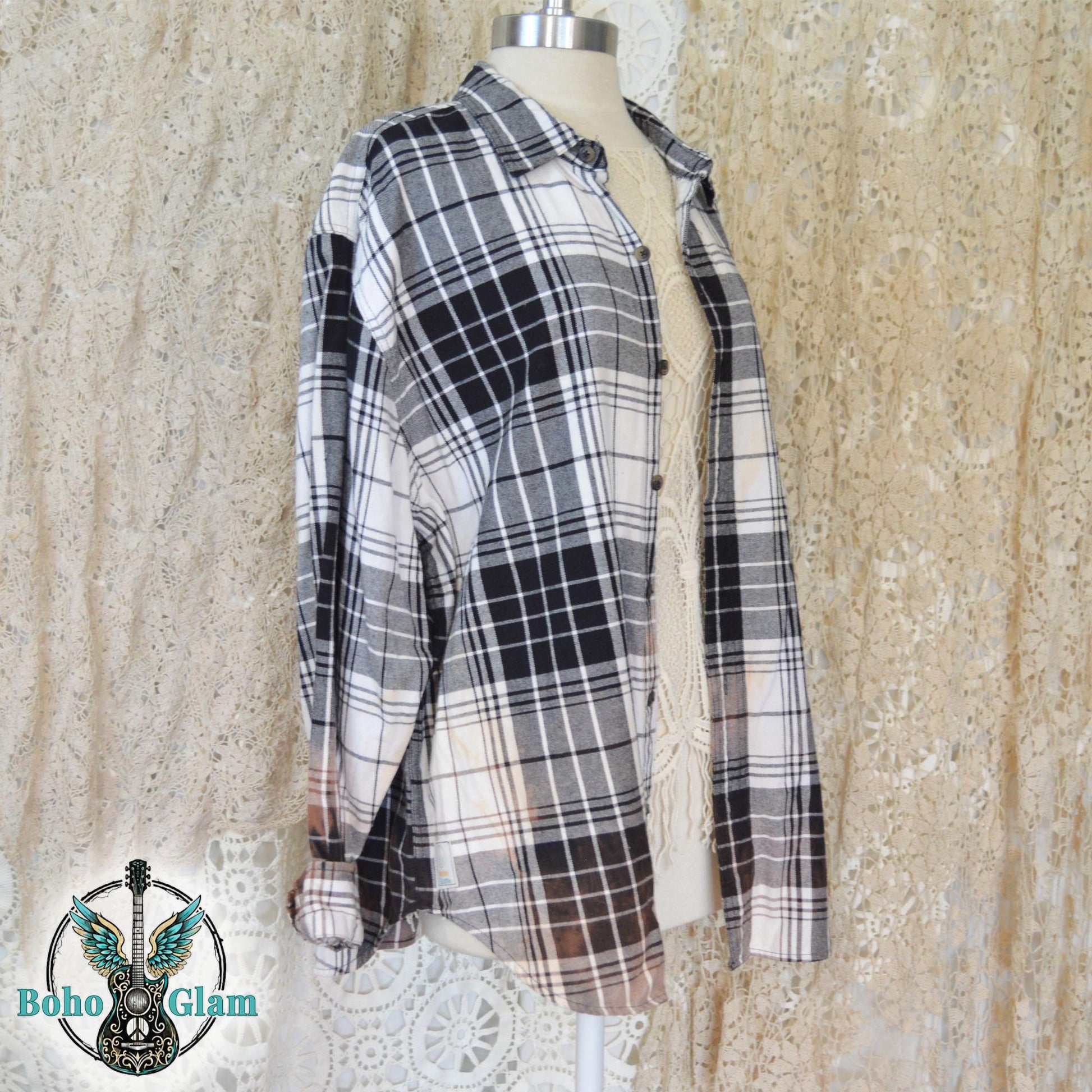 Side View: mannequin display of the oversized black and white plaid flannel showing the long sleeves and relaxed side profile.