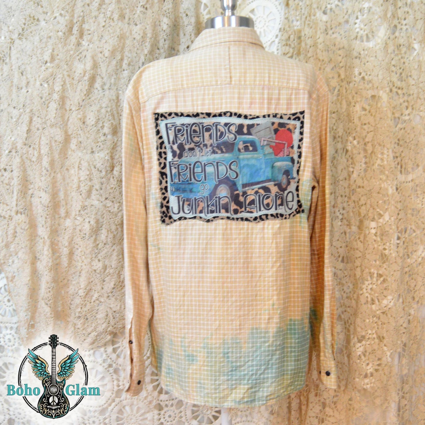 Full Back View: The back of an upcycled shirt on a mannequin highlighting a large graphic patch with a vintage blue truck and leopard print border.