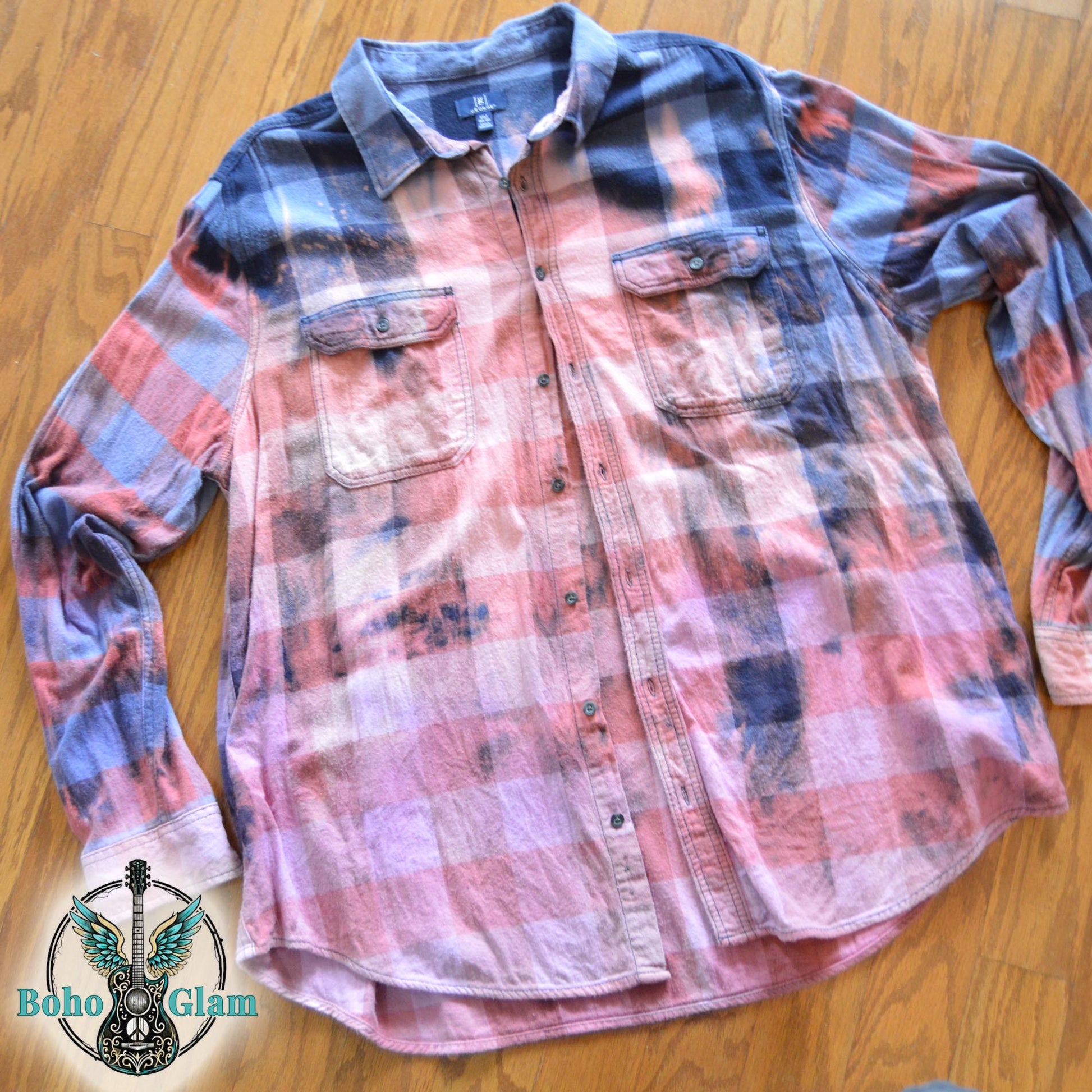 Flat Lay Front: A Men's 3XL Tall bleached plaid flannel shirt in navy and pink tones laid flat on a wood floor showing a unique distressed dye effect.