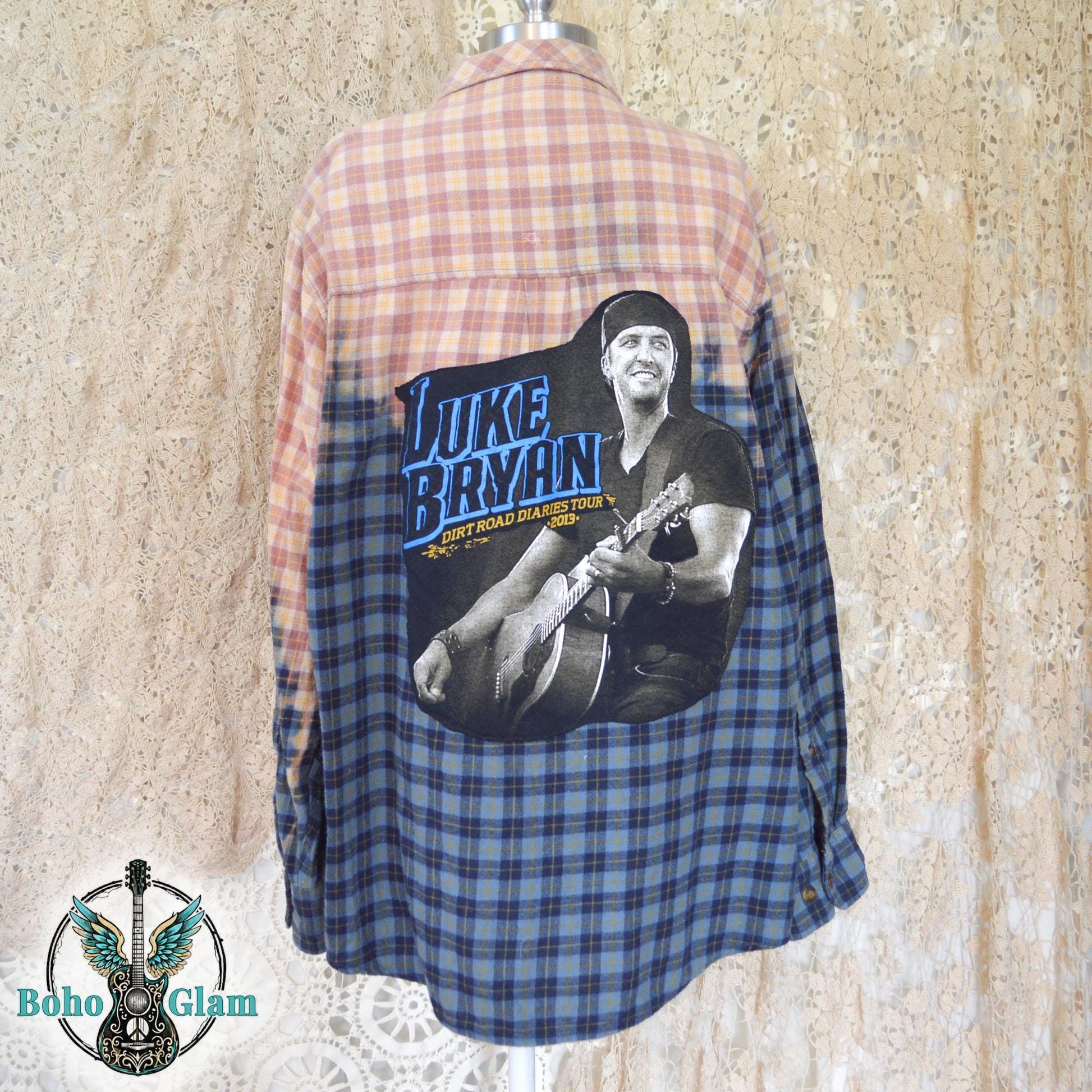 Full Back View: Rear view of the flannel on a mannequin highlighting the large graphic of Luke Bryan playing guitar against the bleached peach plaid.