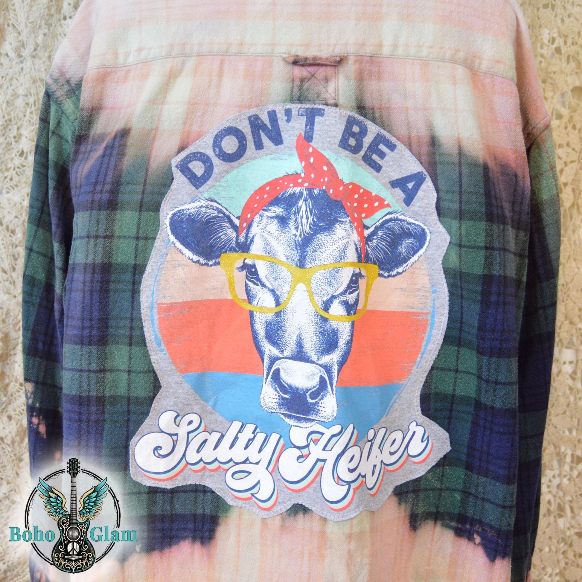 Back View: A Men's Large bleached plaid flannel shirt featuring a large back patch with a cow in glasses and the text "Don't Be A Salty Heifer."