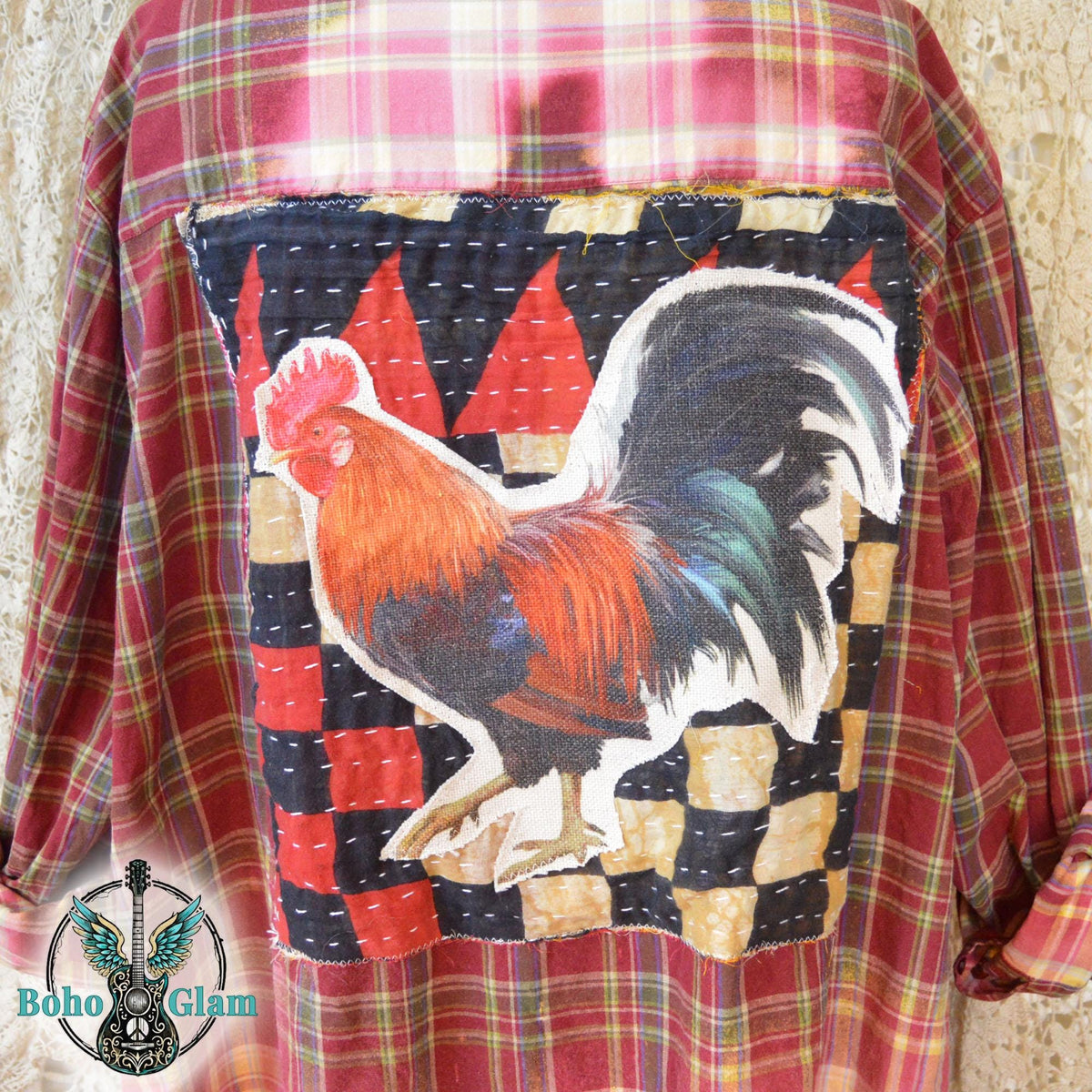 Applique Detail: A close up shot of the back applique featuring a colorful rooster on a kantha stitched patchwork background of black red and tan.