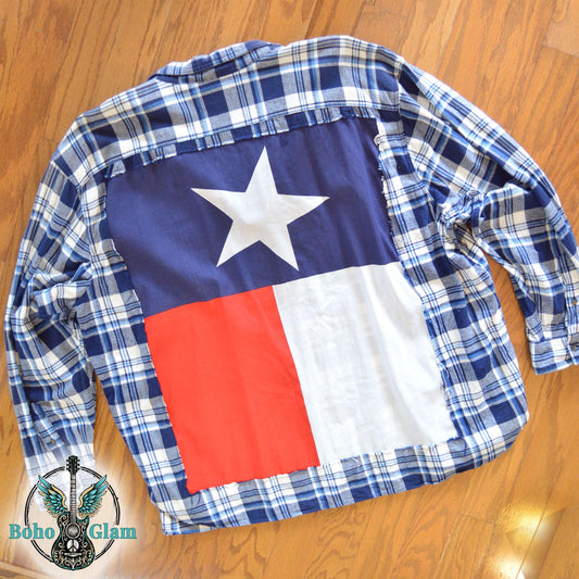 Flat Lay Back: A Mens 4X blue and white plaid flannel shirt featuring a large, vibrant Texas state flag sewn onto the back panel.