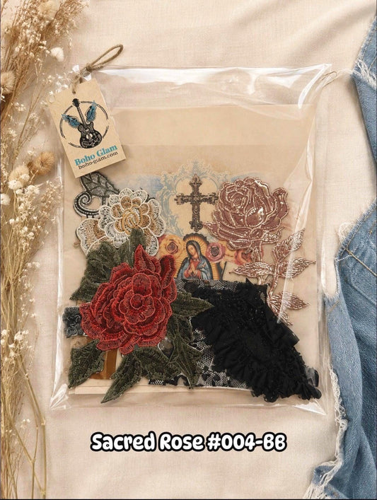 A packaged set of embroidered floral and religious appliques labeled 'Sacred Rose #004-88,' shown inside a clear plastic bag with a hanging tag. The set includes a large red rose, black ruffled fabric, green embroidered leaves, a brown cross, and oth